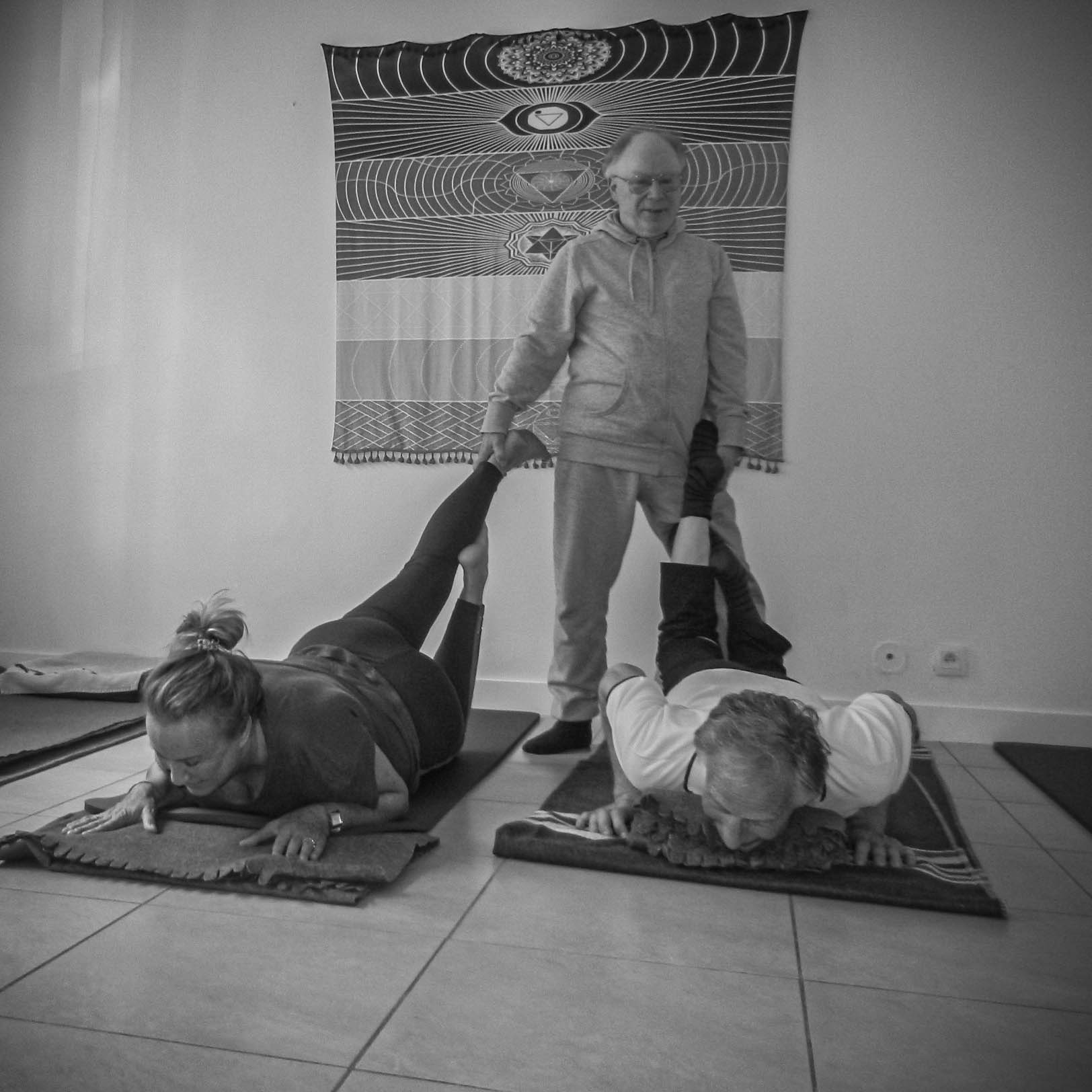 Patrick Noblet accompagnant deux participantes pendant un cours de yoga au centre Creyda